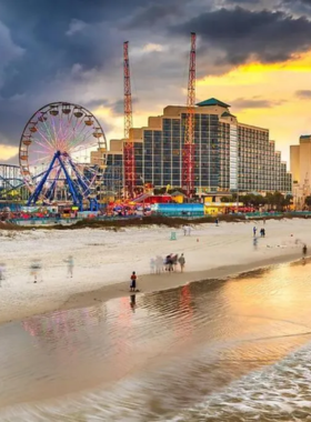 This image shows the wide sandy shoreline of Daytona Beach, with gentle waves and people enjoying the sun and water. The beach also has cars parked on the sand, showcasing the unique feature of driving on the beach