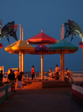 This image shows that the Virginia Beach Boardwalk is a popular 3-mile long stretch with scenic views, vibrant events, and landmarks like the King Neptune statue. Visitors enjoy walking, biking, and relaxing by the ocean.