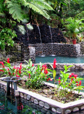 This image shows visitors relaxing in the natural hot springs of Ecotermales, surrounded by lush rainforest near the Arenal Volcano, offering a tranquil and soothing escape in warm, mineral-rich waters.