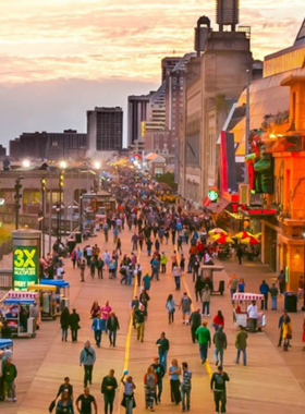 This image shows the iconic Atlantic City Boardwalk, lined with shops, restaurants, and amusement parks, with people strolling along the wooden path, enjoying the sea breeze and lively atmosphere.