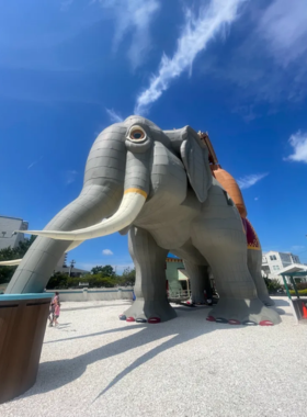 This image shows Lucy the Margate Elephant, a giant 6-story elephant structure, with visitors standing in front of the historic landmark, which has been transformed into a museum and tourist attraction.