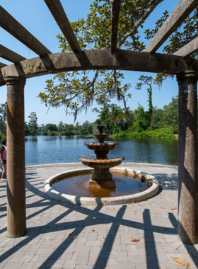 This image shows Airlie Gardens in Wilmington, with vibrant flowers in full bloom, surrounded by lush greenery, and large oak trees, creating a beautiful, serene garden landscape.

