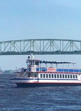 This image shows a boat tour along the Cape Fear River in Wilmington, with a group of people enjoying the scenic beauty of the river, wildlife, and surrounding landscapes on a guided cruise.