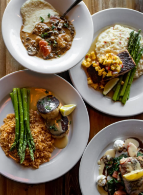 This image shows a delicious seafood meal served at a Wilmington restaurant, with fresh fish, oysters, and shrimp, showcasing the city’s vibrant food scene and coastal cuisine.