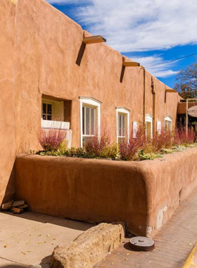 This image shows Canyon Road, lined with over 80 art galleries showcasing contemporary and traditional Native American artwork in a scenic, artistic street.