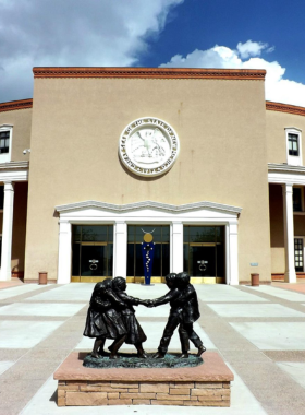 This image shows the New Mexico State Capitol, also known as the Roundhouse, featuring a unique circular design and housing artworks that reflect New Mexico’s history.