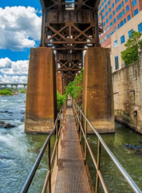 This image shows a scenic hiking trail at the James River Park System in Richmond. The park offers miles of trails for outdoor enthusiasts, with opportunities for hiking, biking, and enjoying the natural beauty of the James River and its surroundings.