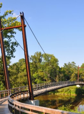  This image shows a cyclist riding along the scenic Neuse River Trail, surrounded by lush greenery, showcasing its tranquil and picturesque setting.