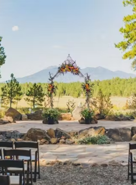  This image shows a vibrant garden path at the Arboretum at Flagstaff, surrounded by colorful flowers, plants, and shady trees.