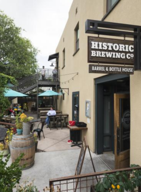  This image shows a cozy craft brewery in Flagstaff, with people enjoying beers, wooden tables, and decorative brewing equipment in the background.