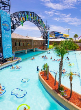 : This image shows visitors enjoying the thrilling water rides at Schlitterbahn Waterpark, with people sliding down water slides and others floating in the lazy river surrounded by lush greenery.