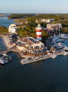  This image shows the Harbour Town marina with the iconic lighthouse, luxurious yachts, and vibrant waterfront dining spaces.