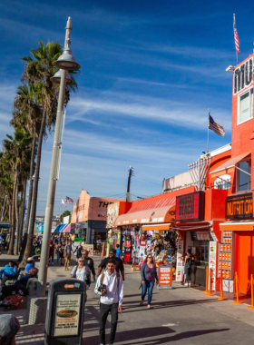 This image shows Venice Beach’s bustling boardwalk with street performers, vibrant murals, and sandy shores, offering a lively experience.