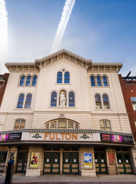  This image shows a live performance at a historic theater in Lancaster, with actors performing a lively play on stage under dramatic lighting, showcasing the local arts scene.