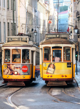 This image shows the iconic Tram 28 navigating through Lisbon’s narrow streets, providing a scenic view of the city’s historic neighborhoods, including Alfama and Baixa.