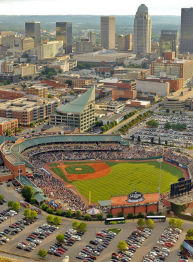 This image shows a Louisville Bats baseball game at Louisville Slugger Field, with a crowd enjoying the game, and children playing on the playground beside the stadium.

