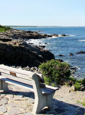  This image shows the picturesque Marginal Way in Ogunquit, Maine, a coastal walking path with beautiful views of the Atlantic Ocean, rocky shorelines, and wildflowers blooming along the way.

