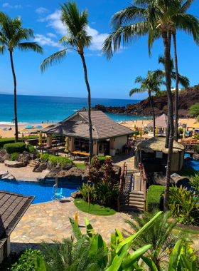 This image shows the calm and clear waters of Napili Bay Beach, ideal for swimming and snorkeling. The beach, surrounded by gentle waves and lush vegetation, provides a peaceful and serene environment for relaxation and outdoor activities.