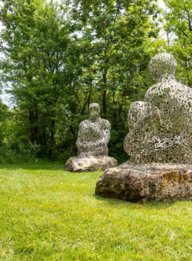 This image shows a beautiful garden with colorful flowers and an impressive sculpture at Frederik Meijer Gardens & Sculpture Park, offering a peaceful environment blending art and nature.