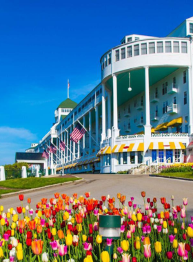  This image shows the iconic Grand Hotel on Mackinac Island, known for its grand architecture and beautiful porch, providing stunning views of the surrounding landscape and Lake Huron.