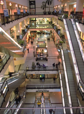 This image shows the bustling underground city (RESO) in Montreal, where visitors walk through a network of tunnels connecting shopping centers, metro stations, and office buildings.