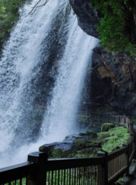 : This image shows the Oconaluftee Indian Village in Cherokee, where visitors can learn about Native American traditions through interactive reenactments and displays of traditional crafts.