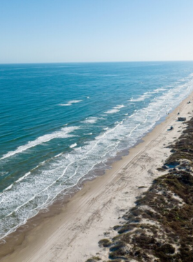 This image shows a pristine beach at Padre Island National Seashore, with gentle waves lapping against the shore. It captures the natural beauty and tranquility of the coastline, making it a perfect destination for relaxation and wildlife spotting.