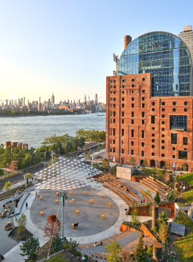 This image shows that Domino Park along the East River blends industrial history and modern design, featuring iconic shipping cranes and elevated walkways, making it a unique and relaxing spot in Brooklyn.