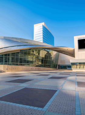 This image shows visitors engaging with an interactive exhibit at the NASCAR Hall of Fame. The display features a racing simulator where guests can experience the thrill of driving a race car, showcasing the excitement of NASCAR.