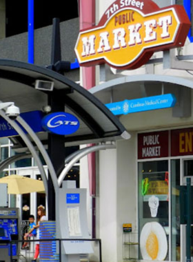 This image shows the bustling atmosphere of The Market at 7th Street in Charlotte, where local food vendors offer fresh, unique meals. The food hall's intimate setting provides a cozy and welcoming environment for people to sample various local dishes.