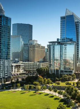 This image shows a panoramic view of Uptown Charlotte’s cityscape, featuring towering skyscrapers and a bustling urban environment. The area is known for its mix of modern architecture, cultural attractions, and vibrant nightlife.