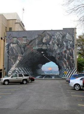 This image shows the Tunnelvision mural and Busted Plug Plaza in Columbia. The giant hydrant sculpture and optical illusion mural are iconic landmarks, offering a playful and unique urban art experience.