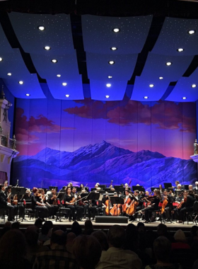 "This image shows the El Paso Symphony Orchestra performing at the Plaza Theatre, with musicians playing classical instruments, providing the community with a cultural experience and performances of both traditional and modern music."