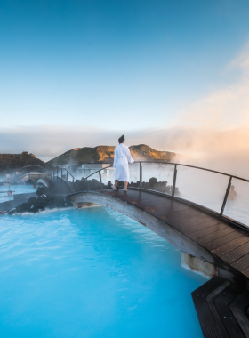 This image shows the soothing, turquoise waters of the Blue Lagoon surrounded by volcanic rocks, offering visitors a relaxing geothermal spa experience in Iceland's stunning landscape.