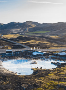 This image shows visitors relaxing in the warm, mineral-rich waters of the Myvatn Nature Baths, located in the North of Iceland, surrounded by volcanic landscapes and soothing scenery.