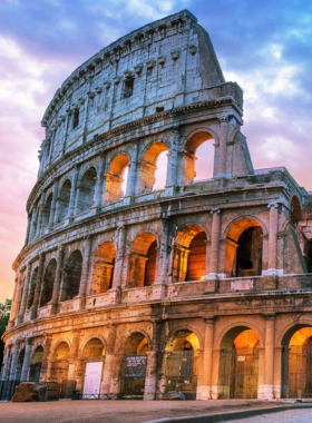 This image shows the iconic Colosseum in Rome, an ancient amphitheater that once hosted gladiatorial battles and other public spectacles. The massive structure, made of stone and concrete, is a symbol of Ancient Rome’s engineering and architectural excellence. Visitors today can explore its grand ruins and learn about its historical significance.