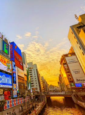 This image shows Dotonbori at night, with bright neon lights illuminating the streets. The iconic Glico Running Man sign and other colorful advertisements create a lively atmosphere, making it one of Osaka's most popular entertainment districts known for its street food and vibrant nightlife.