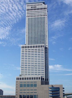 This image shows the unique Gate Tower Building in Osaka, where a highway runs through the middle of the skyscraper. The building stands as an innovative solution to a land dispute, combining architecture and urban planning in a creative way that is unlike any other building.