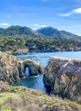 This image shows a hiker enjoying the scenic trails of Monterey, with picturesque ocean views, towering cliffs, and lush greenery, perfect for exploring the natural beauty of the region.