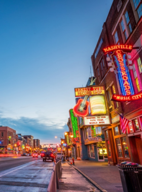 Broadway This image shows the vibrant streets of Broadway in Nashville, filled with neon lights, live music, and crowds of people. Known as “Honky Tonk Highway,” Broadway is the heart of Nashville’s nightlife, offering an unforgettable experience for music fans.