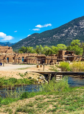 This image shows the Taos Pueblo, an ancient adobe village that has been continuously inhabited for over 1,000 years. The image showcases the traditional architecture and the vibrant culture of the Taos Native American community.