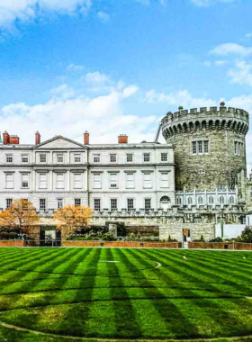 This image shows Dublin Castle, a historic site with elegant State Apartments, medieval stone walls, and lush gardens. Visitors are seen walking through ornate rooms, admiring its architecture, and learning about Dublin’s political history.