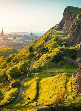 This image shows Holyrood Park with Arthur’s Seat, a majestic extinct volcano in Edinburgh, surrounded by lush greenery and hiking trails, offering breathtaking views of the city skyline from the summit.