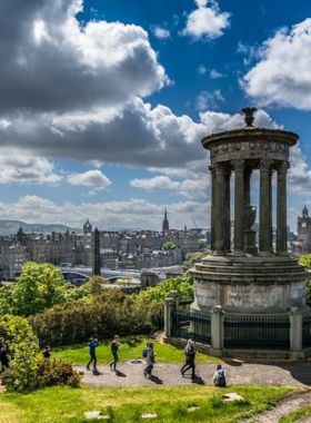 This image shows Calton Hill in Edinburgh with its iconic monuments, including the unfinished National Monument and Nelson Monument, offering panoramic views of the city, perfect for photographers and tourists.