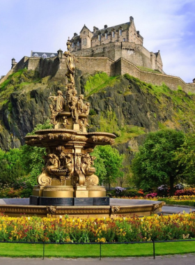 This image shows Princes Street Gardens, a peaceful green space in Edinburgh with well-maintained flower beds, iconic landmarks like the Scott Monument, and visitors enjoying the serene surroundings.