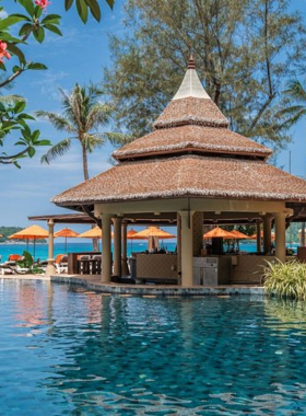 This image shows Beyond Kata Resort located on Kata Beach, Phuket. The image highlights the resort's upgraded rooms, tropical surroundings, and guests enjoying a relaxing massage, with a stunning view of the beach and serene atmosphere.