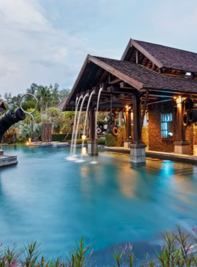 This image shows The Slate Phuket, a boutique luxury resort. The image captures the resort's unique sustainable architecture, where guests are enjoying a relaxing spa treatment and set-menu dining featuring local flavors and eco-friendly practices.