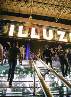 This image shows the vibrant interior of Illuzion Nightclub in Phuket. The scene features dazzling lighting effects, a spacious dance floor filled with enthusiastic partygoers, and a grand stage for DJ performances, highlighting the energetic atmosphere of one of Phuket’s premier nightlife venues.