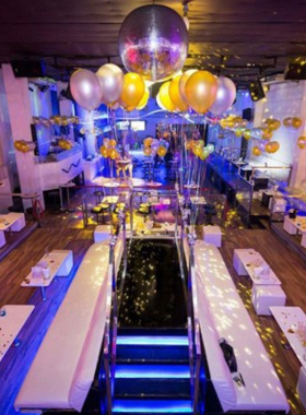 This image shows the sleek and modern interiors of White Room Nightclub. The clean white decor, ambient lighting, and groups of people dancing create an intimate yet exciting nightlife experience on Phuket's Bangla Road.