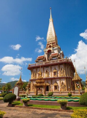 This image shows that Wat Chalong Temple in Phuket is a peaceful and sacred Buddhist site. The image showcases the ornate architecture of the temple with golden statues and intricate designs, making it an excellent location for cultural and architectural photography.